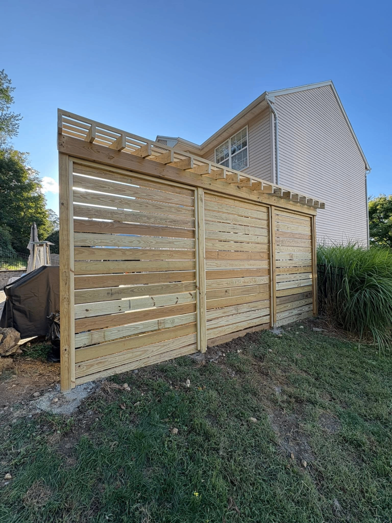 Custom wood privacy fence with pergola top detail
